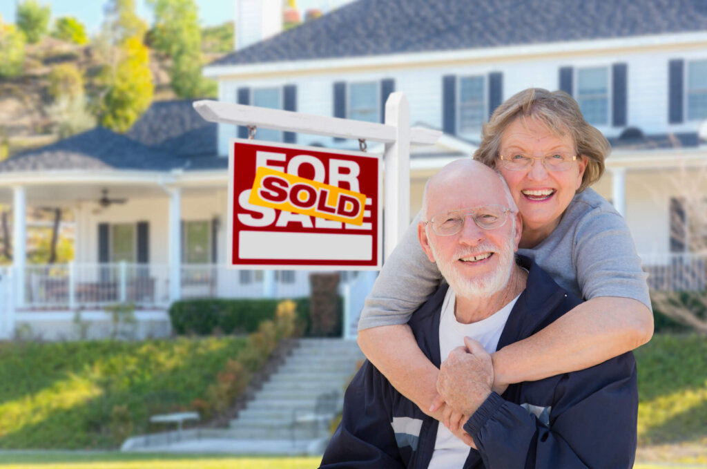 A happy couple stands in front of their new investment property in Houston.